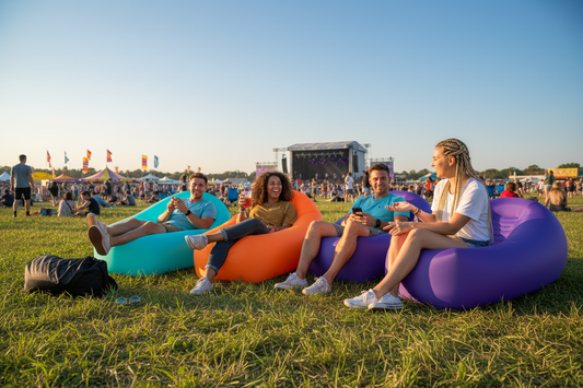 Friends relaxing at a festival on colorful portable inflatable loungers, perfect for outdoor fun and trending gifts