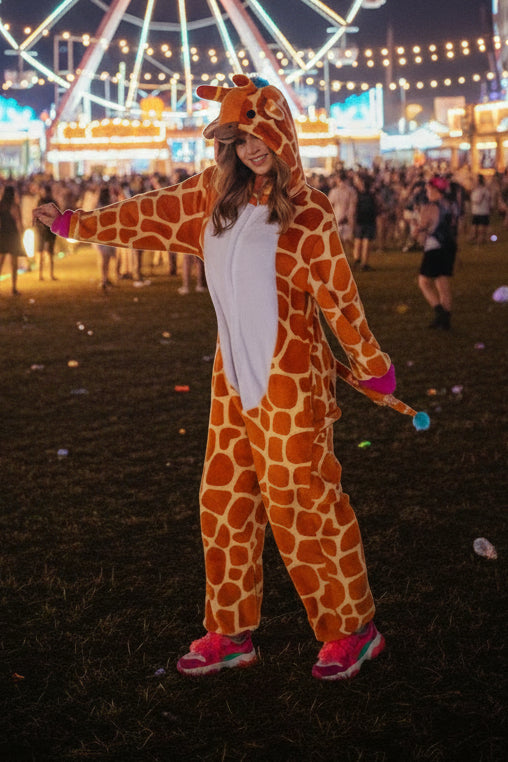 Person wearing a giraffe-themed onesie on a white background