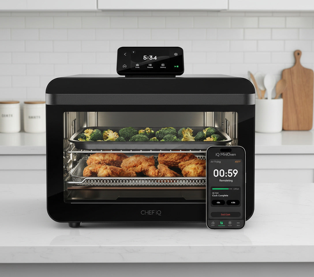 ChefIQ MiniOven with food inside and a smartphone displaying the app interface.